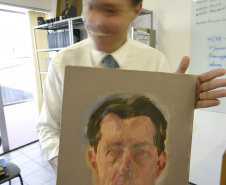 O chinês Tong Yanrunan trabalha com retratos "face a face". Na foto, o diretor do MCAA com obra pintada pelo artista.Foto: Kraw Penas/SECC