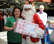 Alessandra recebe do Papai Noel presente que simboliza doações. Foto: Sanepar
